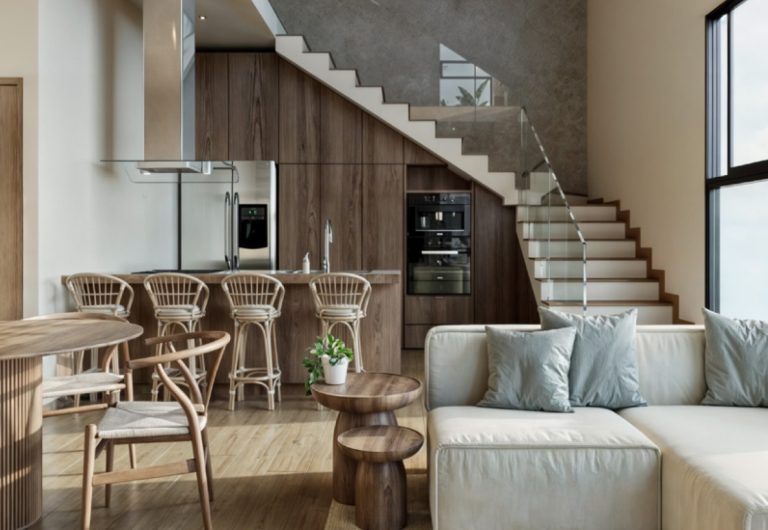 Sala y cocina del modelo Marbella en Vigía Sky Tower, diseño moderno de doble altura con escalera y barra.